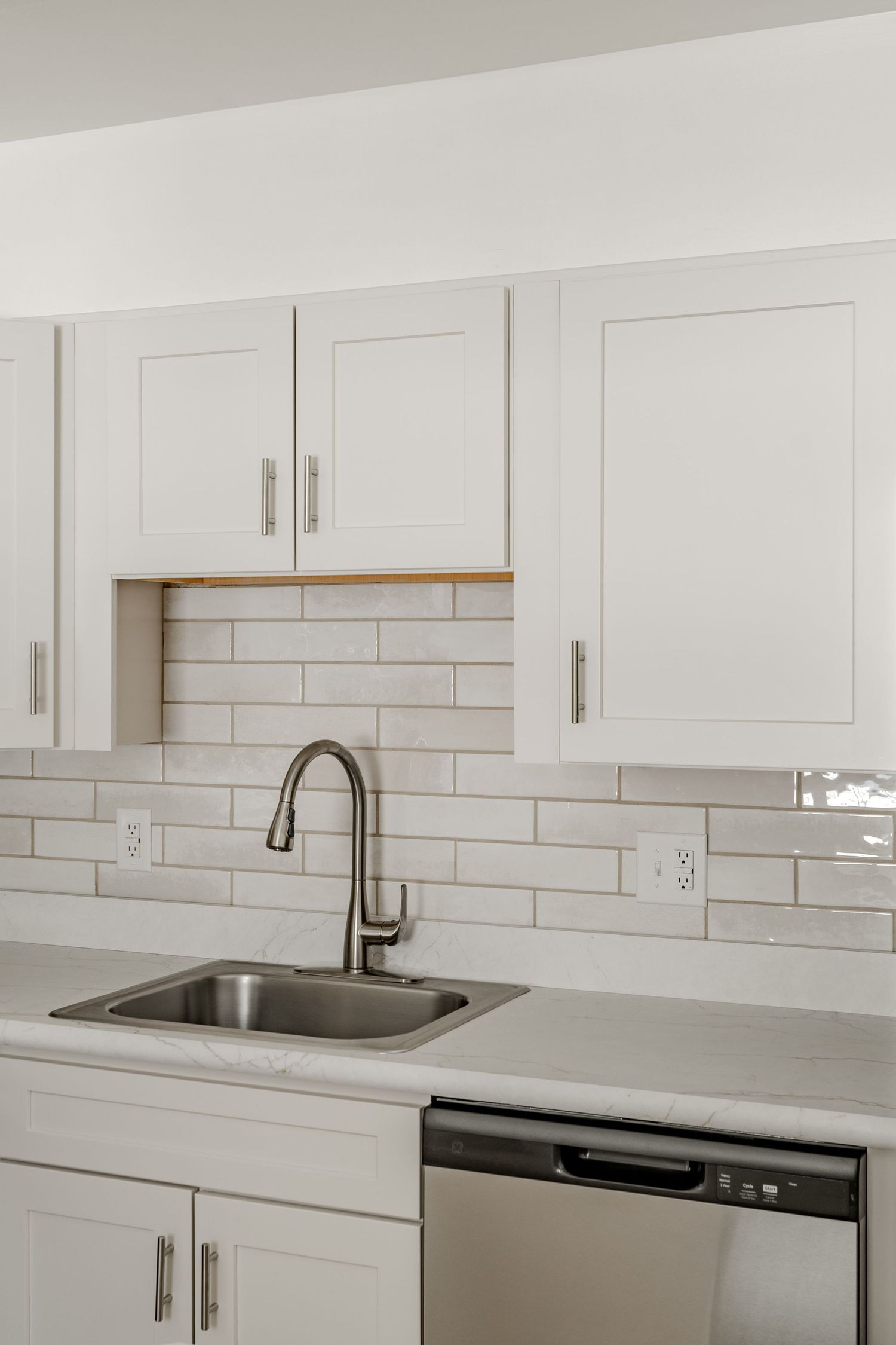 Kitchen with white shaker cabinets, handmade subway tile backsplash and a stainless sink