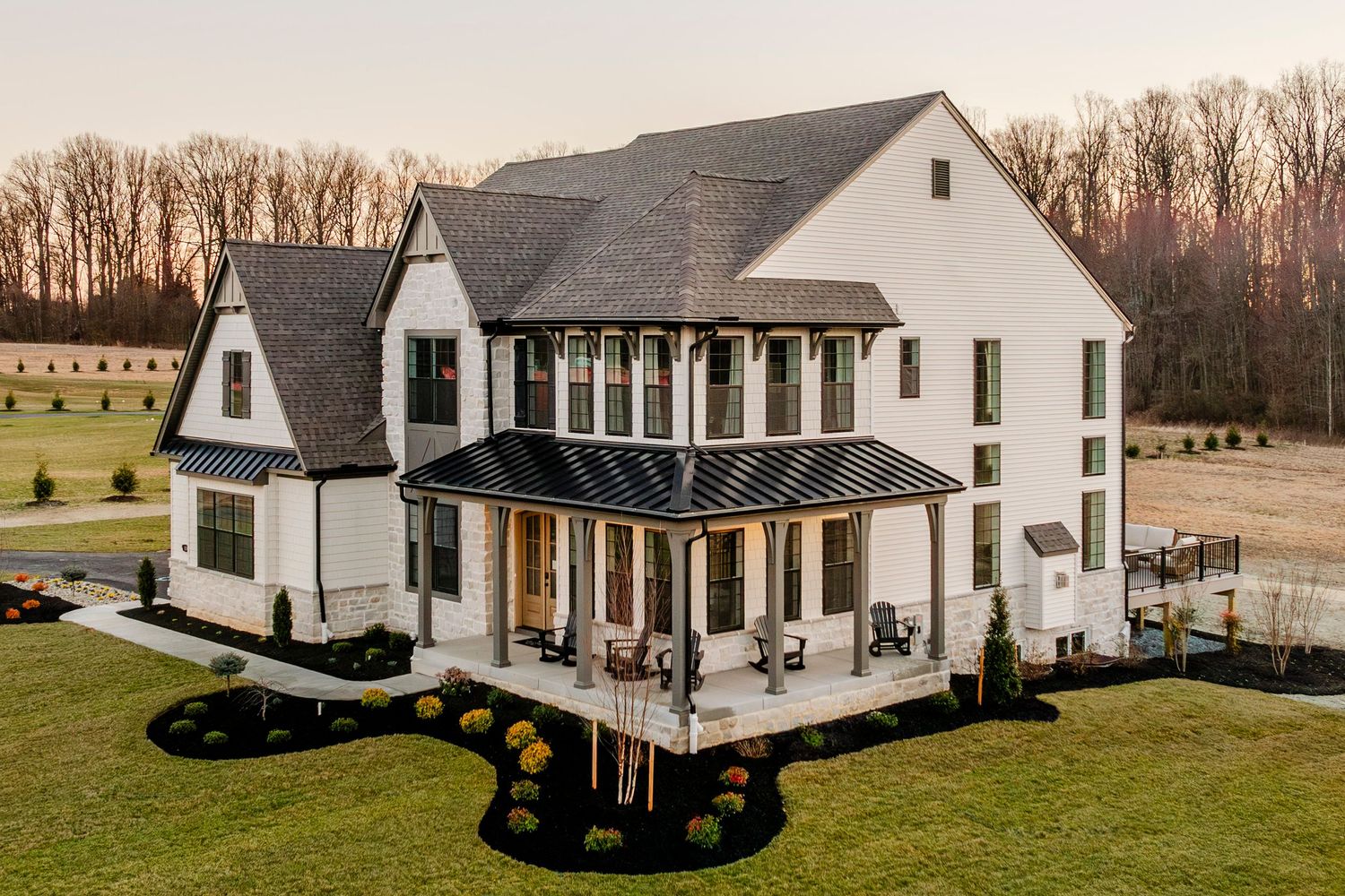 Stone-accented home exterior with a covered front porch, rocking chairs and gabled rooflines