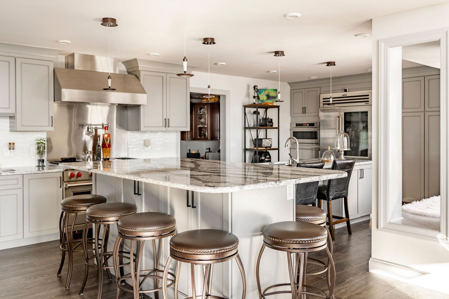 Kitchen with a large granite island, gray cabinetry, industrial shelving and a paneled refrigerator