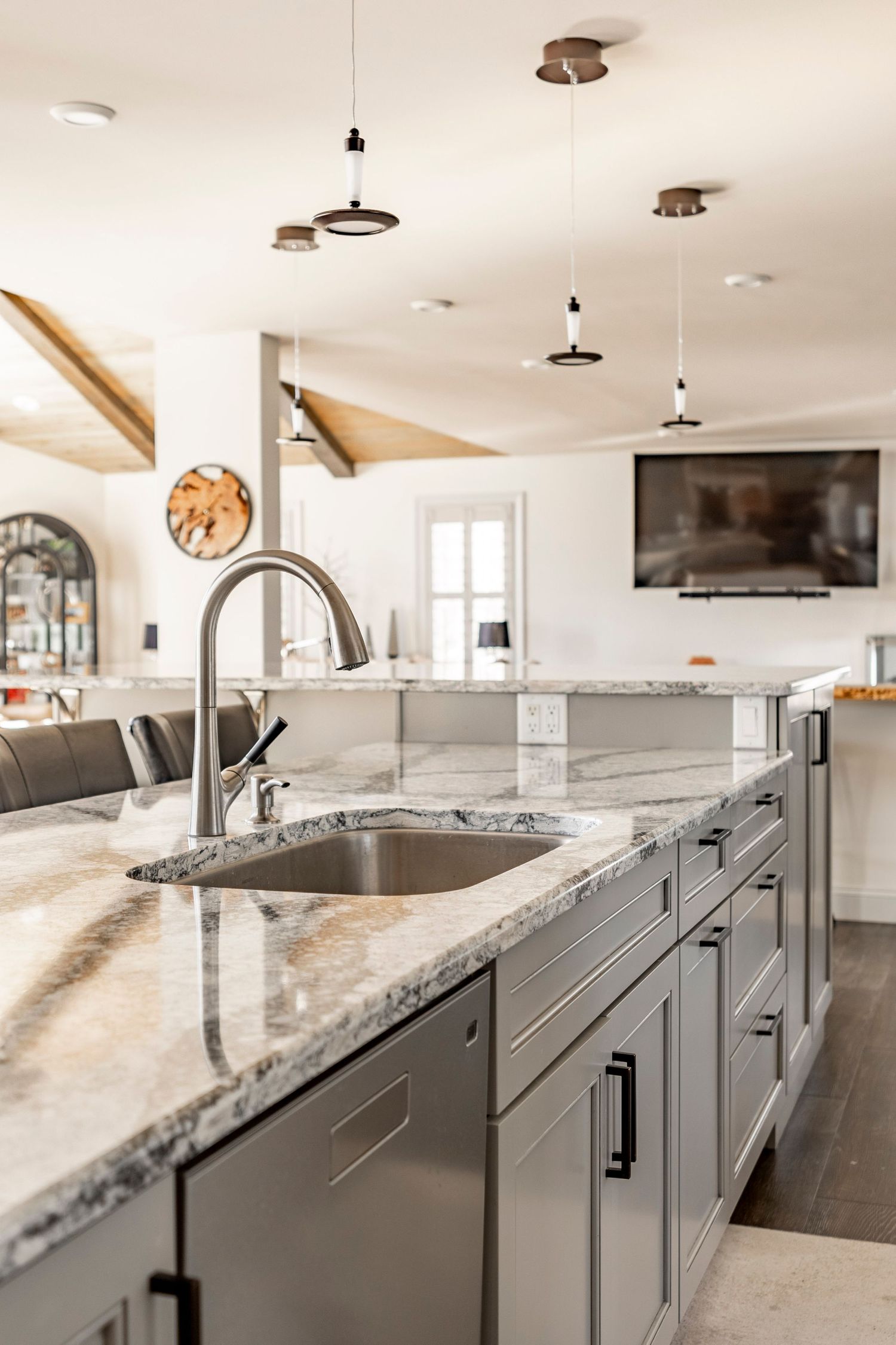 Close-up of a granite kitchen island with an undermount sink and gooseneck faucet
