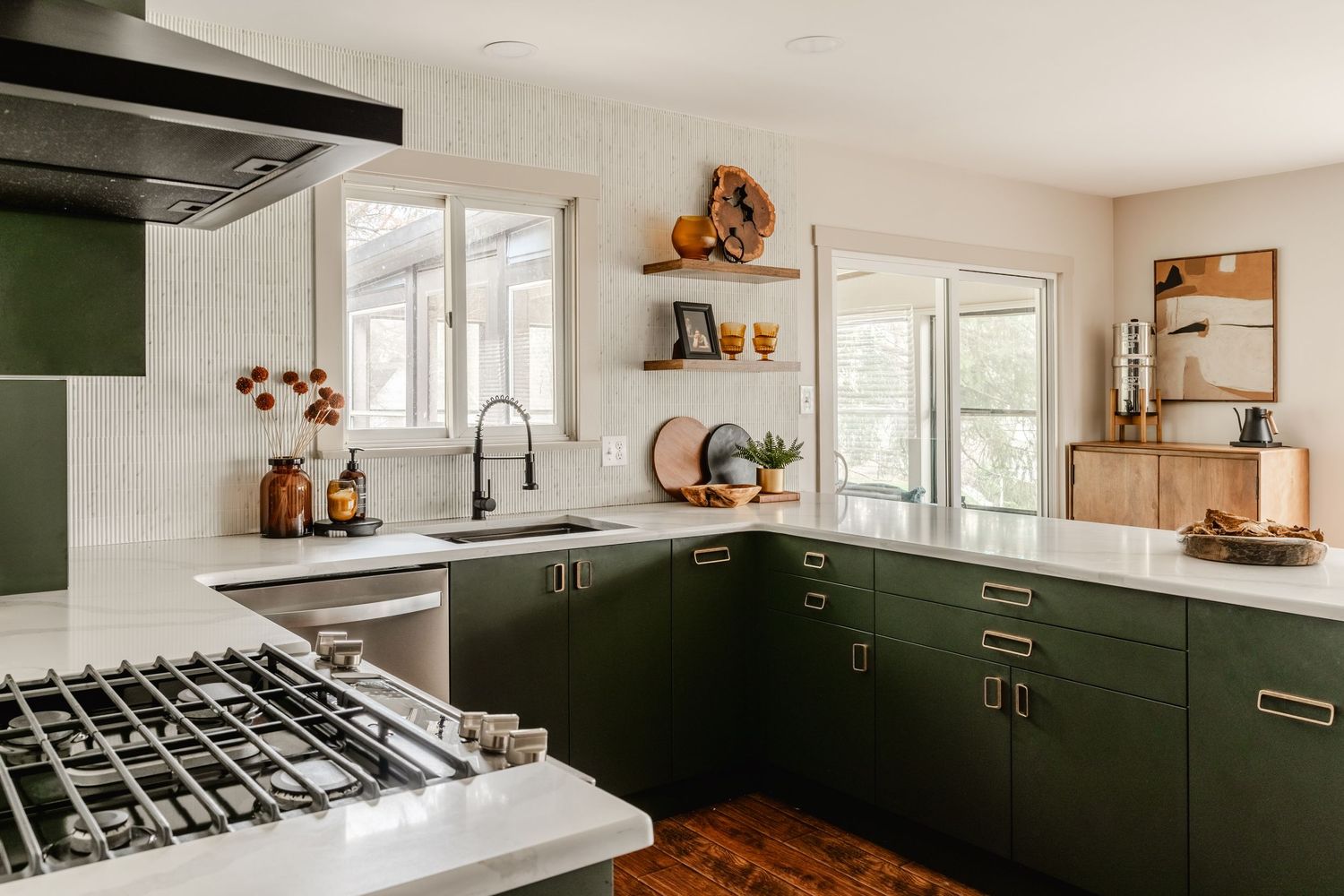 Kitchen with a stainless refrigerator, olive cabinetry and a doorway to a barn-door laundry room