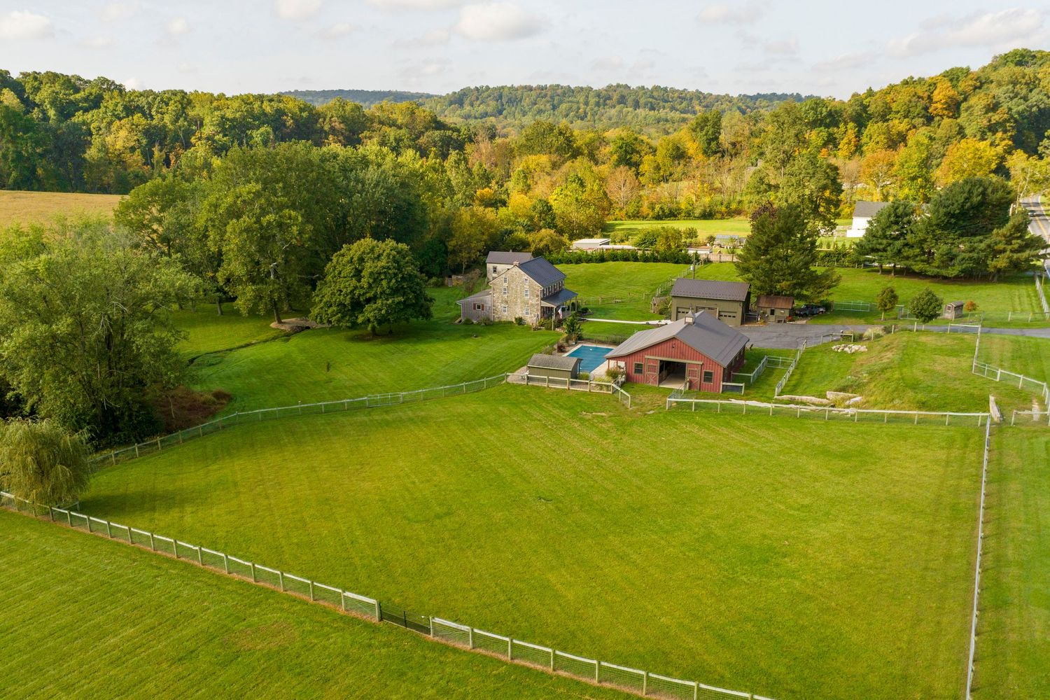 Drone view of a farmhouse with a barn pool house