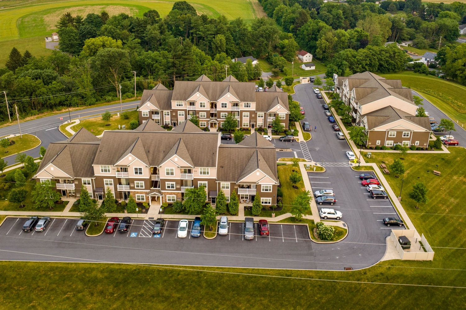 Aerial view of a multi-building apartment complex with landscaped courtyards and parking