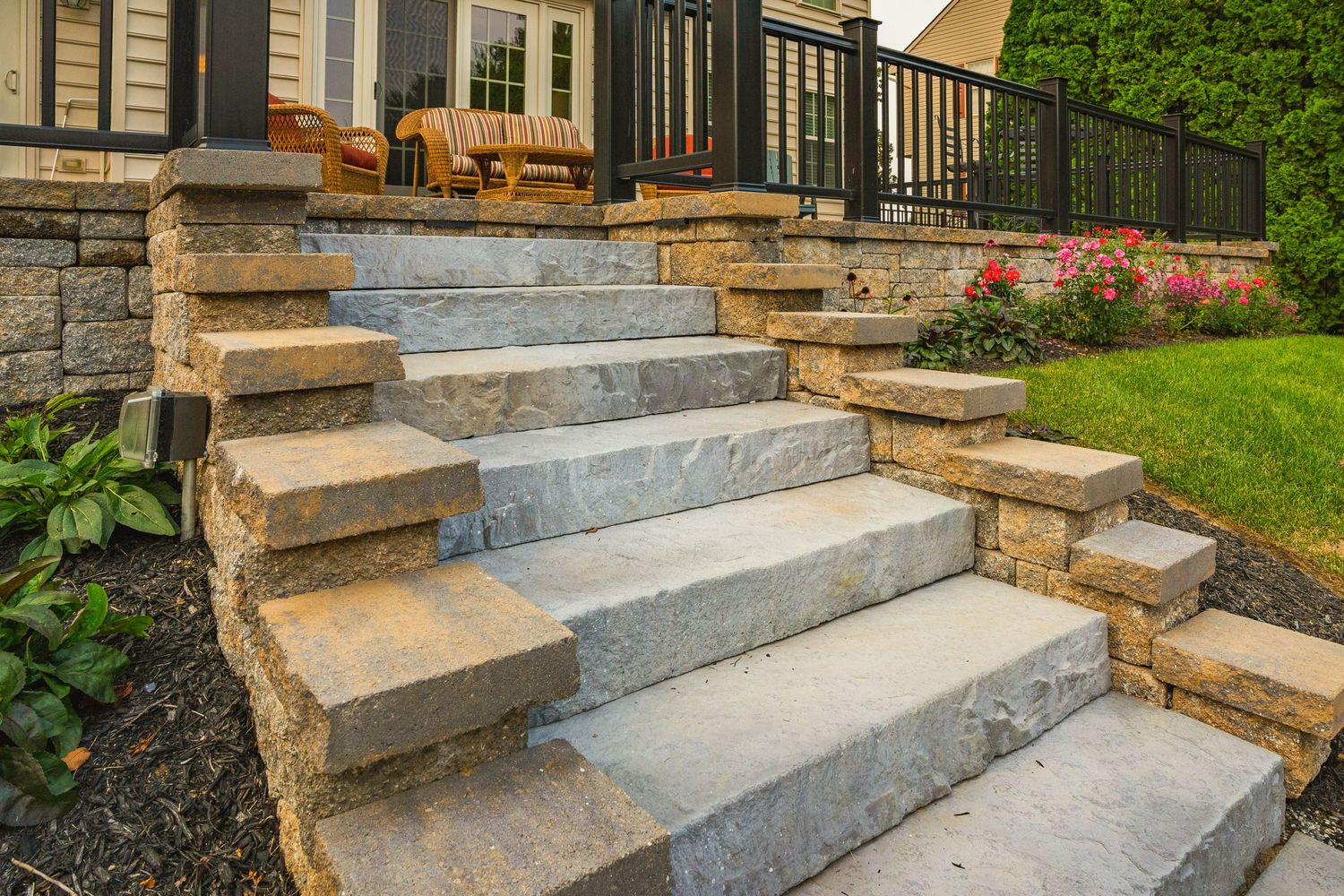 Close-up of stone patio steps with landscape lighting leading to a covered porch