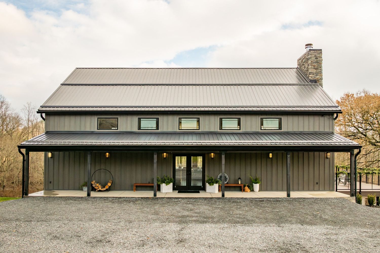 Barn-style home exterior with board-and-batten siding, metal roof and covered front porch