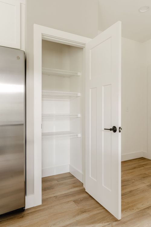 Walk-in pantry with white wire shelving and hardwood flooring