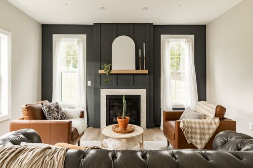 Living room with a black paneled accent wall, fireplace and leather seating