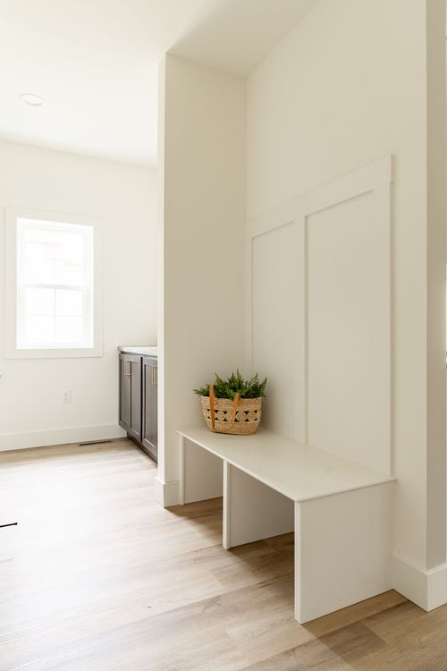 Built-in mudroom bench with a woven basket beneath a window