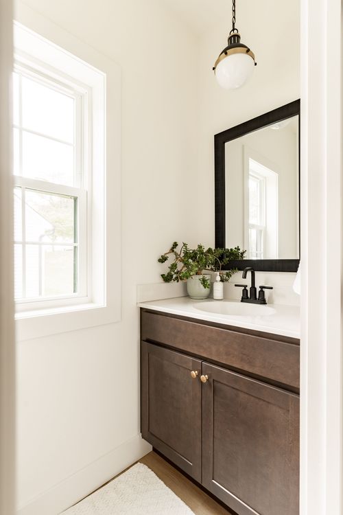 Powder room with a dark wood vanity, pendant light and framed art