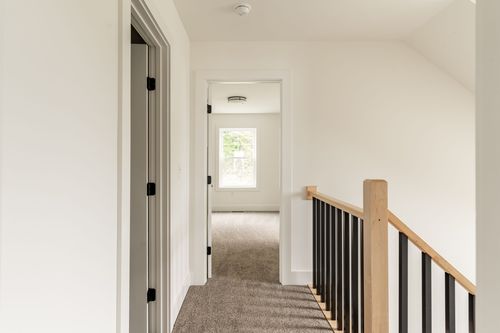 Upstairs hallway with a skylight window and black stair railing
