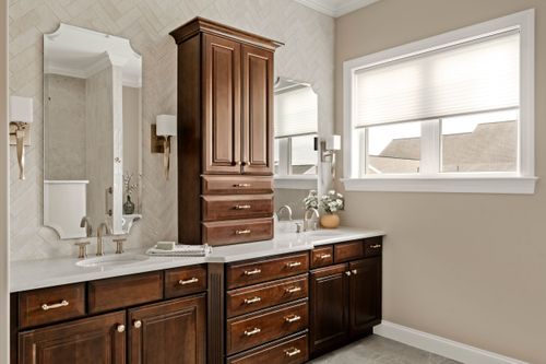 Bathtub and shower combo with black fixtures and patterned tile flooring