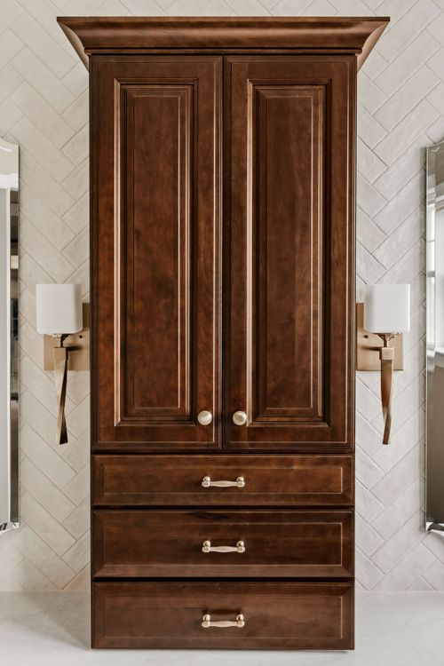 Bathroom vanity with dark cabinetry, towel rings and patterned floor tile