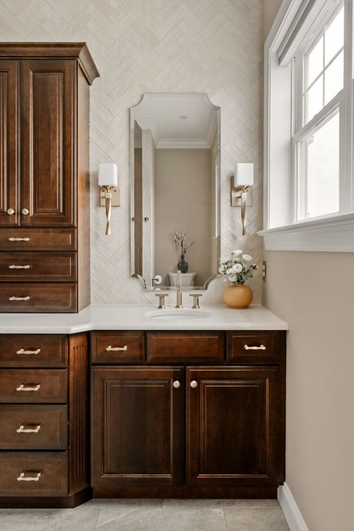 Close view of dark wood cabinet drawers with brushed brass pulls and knobs