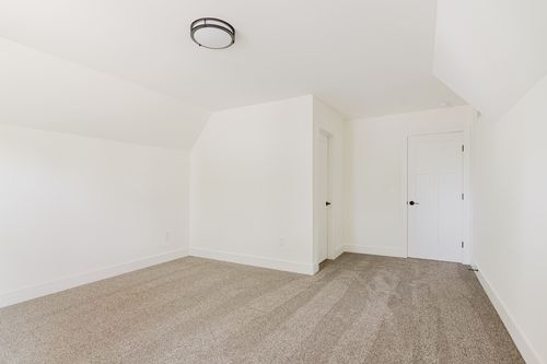 Unfinished bedroom corner with a closet door and view to the hallway