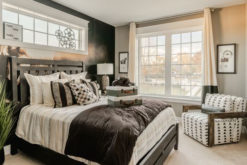 Bedroom with black wood bed frame, film-reel wall art and a patterned accent chair