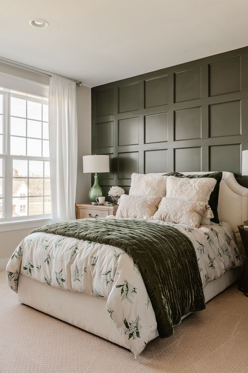 Bedroom with olive paneled wall, upholstered headboard and green velvet throw