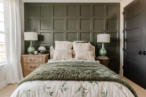 Bedside detail with wood nightstand, green glass lamp and olive paneled wall