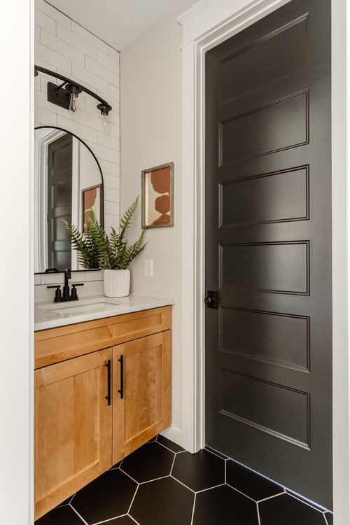 Tub and shower combo with green subway tile and matte black fixtures