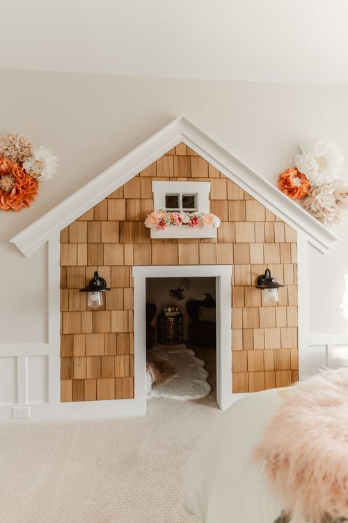 Built-in kids playhouse nook with cedar shake siding and a flower box window