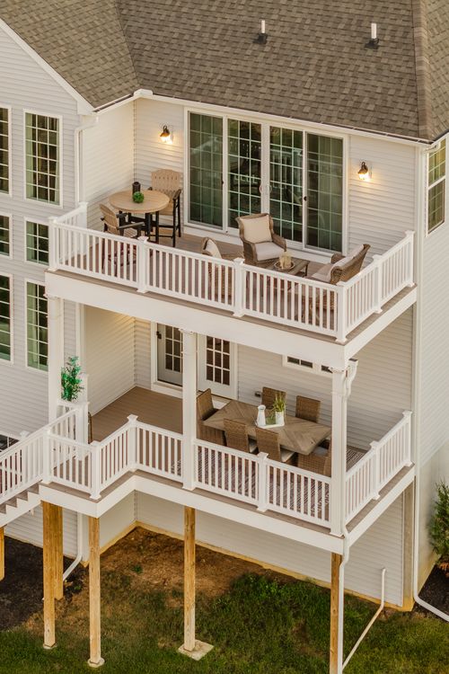 Aerial rear view of a home's stacked decks with dining and lounge seating