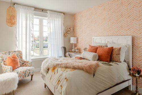 Reading nook with a floral accent chair, macrame pillow and rattan pendant light