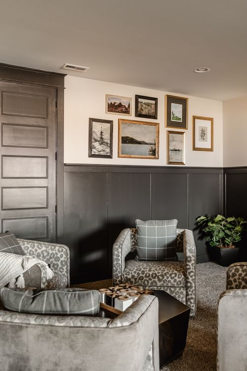 Basement seating area with leopard-print chairs beneath a framed gallery wall