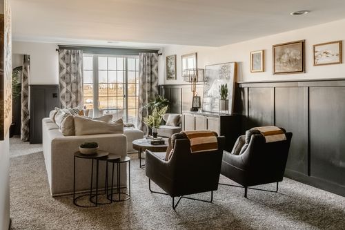 Basement sitting nook with a leather armchair, plaid throw and gallery wall
