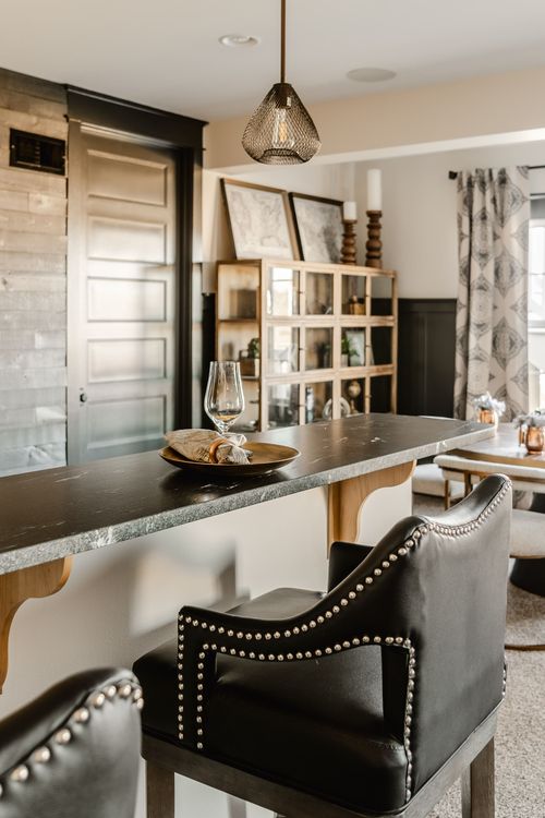 Basement dining nook with leather chairs, pendant light and wood cabinetry