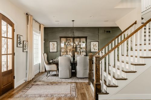 Dining room with a green shiplap wall, chandelier and a formal dining table