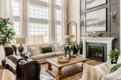 Fireplace with a white mantle, driftwood decor and a black tiled surround