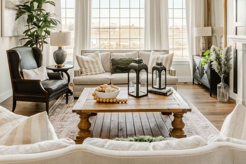 Living room seating with black wingback chair, striped pillows and reclaimed wood coffee table