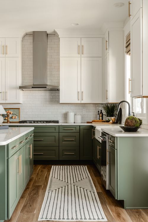 Kitchen sink area with farmhouse sink, black faucet and sage cabinets beneath a window