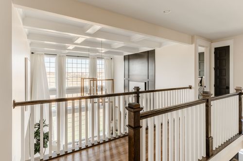 Upstairs hallway with coffered ceiling and dark wood stair railing