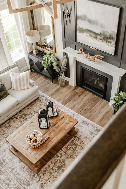 Aerial view of a living room with fireplace, layered art and a wood coffee table