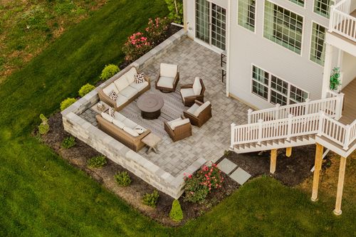 Aerial view of a stone patio with wicker sofas, chairs and a round fire table