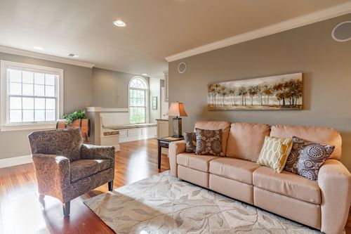 Bonus room with a curved built-in window seat beneath an arched window
