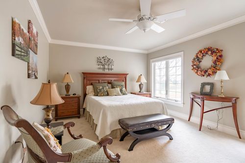 Bedroom with a cherry wood bed frame, floral wreath, and matching nightstands