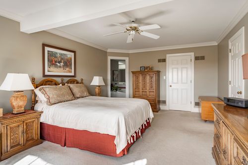 Bedroom with an equestrian painting, four-poster bed, and a wood armoire
