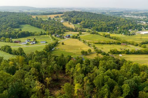 Aerial view of a wooded ravine surrounded by patchwork farm fields