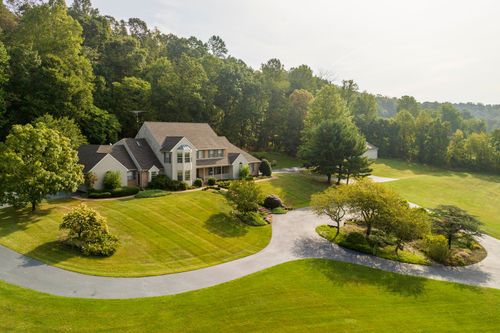 Aerial view of a two-story home with attached garage and manicured landscaping