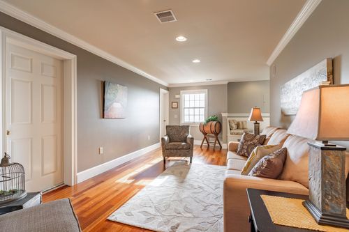 Sitting area with a patterned armchair, area rug, and hardwood flooring