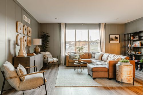 Living room with a leather sectional, open bookshelf styling and a gallery wall