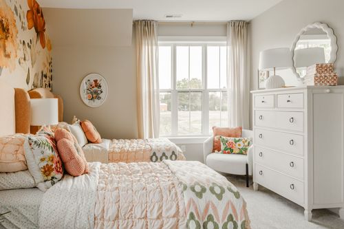Kids' bedroom with twin beds, a floral wallpaper accent and a white six-drawer dresser
