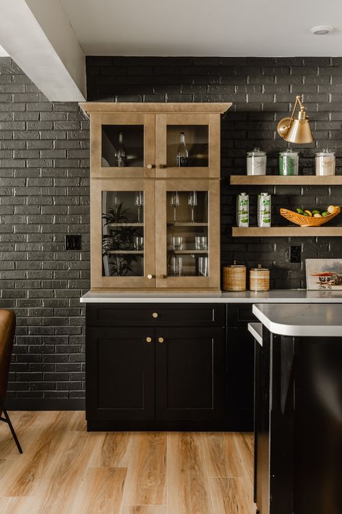 Wet bar corner with a wood hutch, black brick backsplash, brass sconce and open shelves