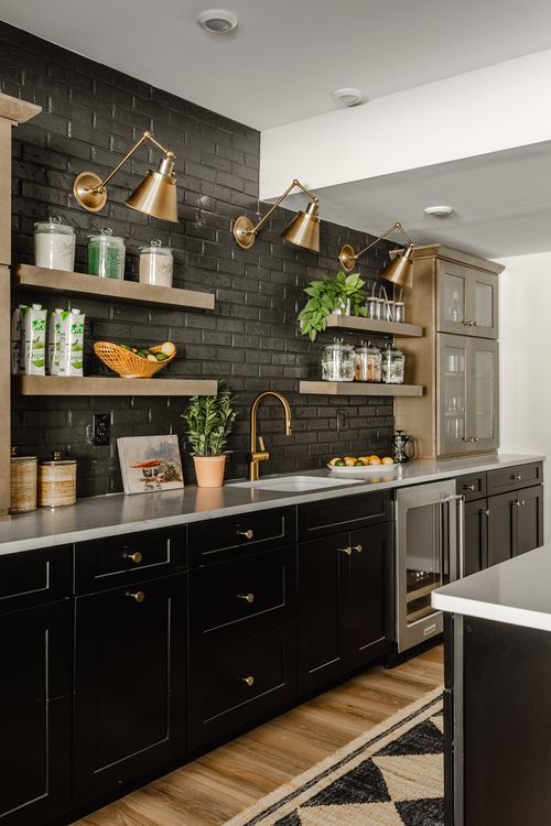 Basement bar with black cabinetry, black brick backsplash, gold sconces and open shelving