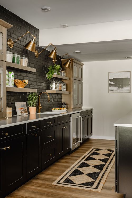 Basement bar with black cabinetry, gold sconces and a woven diamond-pattern runner rug