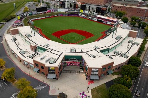 Aerial view of a covered baseball stadium beside a green outfield in downtown Lancaster