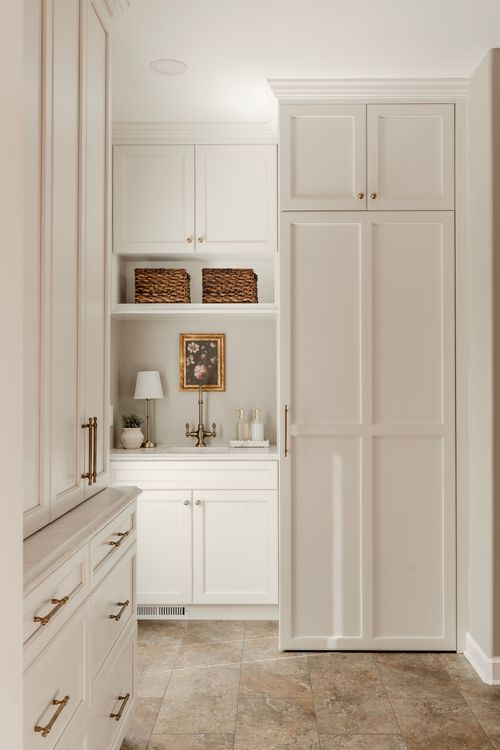 Mudroom hallway with a marble-top sink nook, woven storage baskets and floral wall art