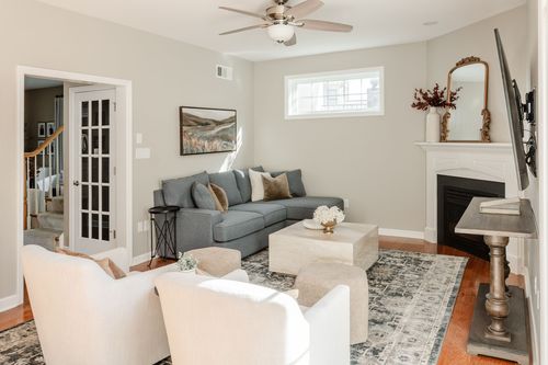 Living room in Lancaster, PA with a blue-gray sofa, white mantel fireplace and ceiling fan
