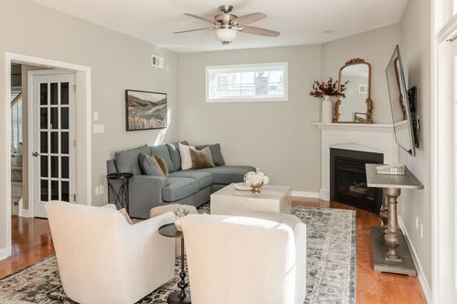 Living room with a blue-gray sectional, corner fireplace and mounted TV